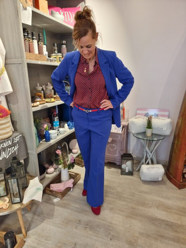 Frau stehend in clematis blauem Blazer mit dazu passender Hose mit geradem Schnitt und Bootcut