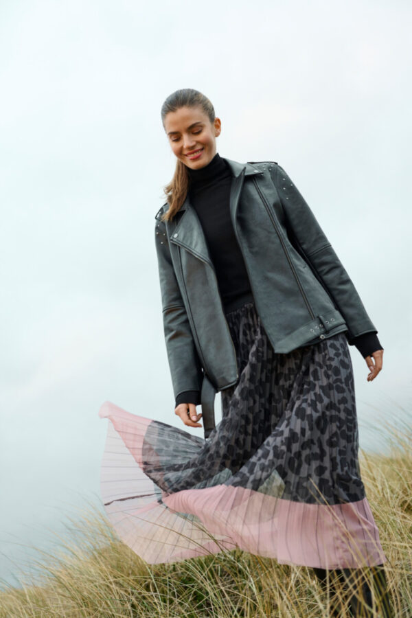 Frau in Tüllrock mit Leoprint in grauschwarz und Rockende in zartrose und Lederjacke gekleidet