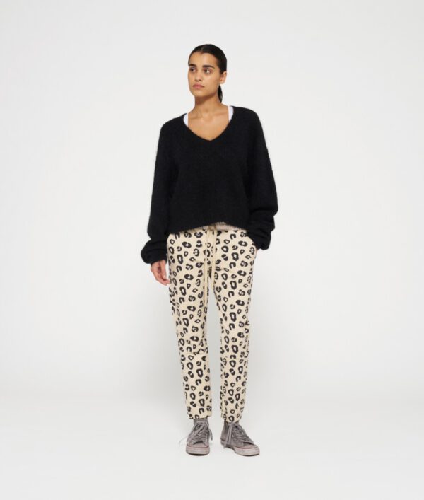 Frau in Ganzfigur trägt cropped Jogpants von 10days mit Leoprint in creme schwarz und gummizug am Hosenende