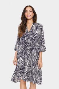 Kurzes EdaSZ Sommerkleid mit abstraktem Print in Off-White und Marineblau, locker geschnitten. Mit V-Ausschnitt, ellbogenlangen Ärmeln und leicht ausgestelltem Saum. Aus weichem Webstoff gefertigt. Das Model ist 175 cm groß und trägt Größe S.